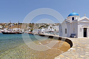 View of the white village and harbor of the Greek island of Mykonos on the Aegean sea.