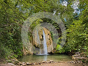 View of wild waterfall (Cascata di Fossi) near Genga in the green wood