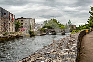 View of the William O`Brien on the Corrib river from the pedestrian walkway, the green dome of the cathedral in the background