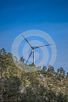 View of a wind turbine on top of mountains