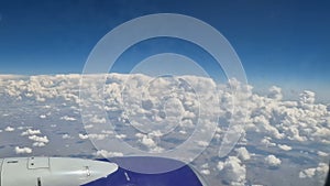 The view from the window of an air plane to the clouds, blue sunny sky.