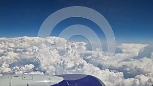 The view from the window of an air plane to the clouds, blue sunny sky.