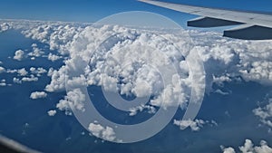 The view from the window of an air plane to the clouds, blue sunny sky.