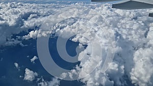 The view from the window of an air plane to the clouds, blue sunny sky.