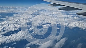 The view from the window of an air plane to the clouds, blue sunny sky.