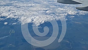 The view from the window of an air plane to the clouds, blue sunny sky.