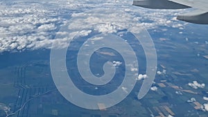 The view from the window of an air plane to the clouds, blue sunny sky.