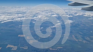 The view from the window of an air plane to the clouds, blue sunny sky.