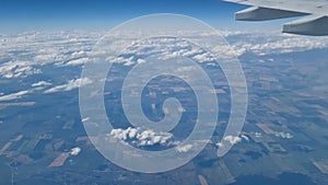 The view from the window of an air plane to the clouds, blue sunny sky.