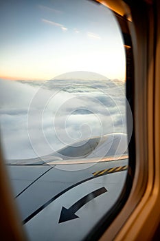 View from the window of an airplane with beautiful cloudy sky at sunrise. travel concept