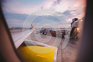 The view from the window of the airplane porthole at dawn at the airport of Barcelona. Theme of romance on a journey. Tourism and