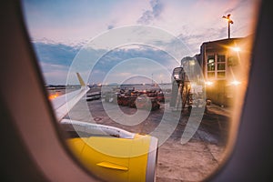 The view from the window of the airplane porthole at dawn at the airport of Barcelona. Theme of romance on a journey. Tourism and