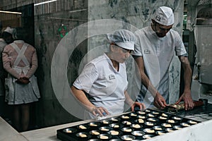 A view through the window of a cafe or glass as a chef prepares a traditional Portuguese dessert called Pastel de Nata.