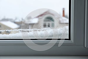 View of window covered with snow on winter day