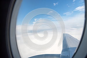 View from the window of a flying passenger plane on the wing, sky and clouds