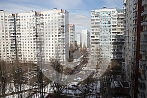 View from the window of a high-rise building into the courtyard and panel houses in winter in spring photo