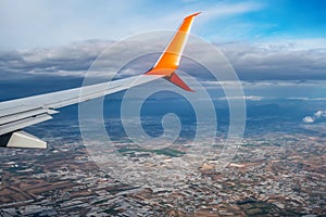 View from the window of the orange and white wing of an airplane flying over Antalya Turkey. Air travel concept. Beautiful