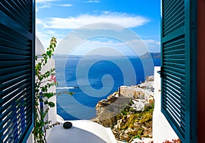 View from a window overlooking the sea, caldera and whitewashed village of Oia on the island of Santorini Greece
