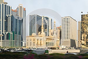 View from the window of the tourist bus to the Al Rahimoon Mosque and nearby buildings in Sharjah city, United Arab Emirates