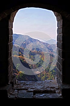 View from the window of a watch tower of the Mutianyu section of the Great Wall of China, surrounded by green and yellow