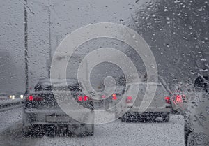 View through windshield of the blocked vehicles on highway at snowfall