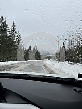 View from the windshield of the car on the road and rainy winter weather