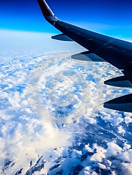 View of the wing of an airplane, clouds, earth