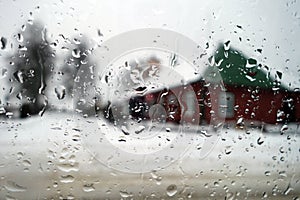 View on winter house through wet windshield with rain drops