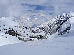 View on winter mountain landscape at Stubai Gletscher ski area with snow covered peaks at spring sunny day. Blue sky