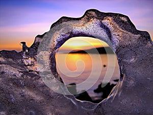View of winter sunset through holes in ice