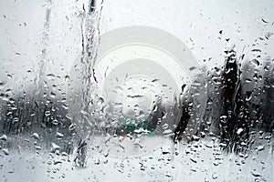 View on winter town through wet windshield with rain drops