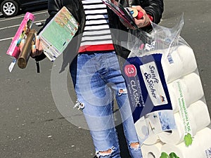 View on woman carrying one final bag of rationed toilet paper and toiletries
