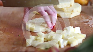 View of woman hands cutting pineapple into pieces
