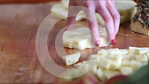 View of woman hands cutting pineapple into pieces