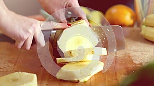 View of woman hands cutting pineapple into slices