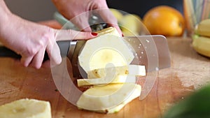 View of woman hands cutting pineapple into slices