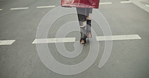 View of woman legs wearing high heels, going by a sidewalk