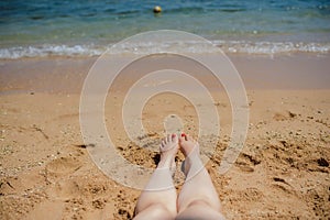 view of woman`s legs on the beach
