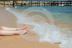 View of woman`s legs on the beach