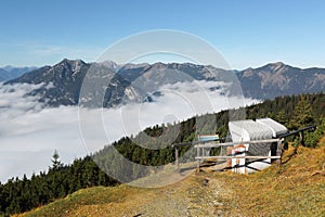 View of a wooden bench facing the beautiful panorama of Mountain Zugspitze from top of Mount Wank