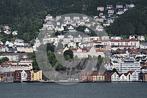 View of wooden coloured houses on the background of mountains, Bergen