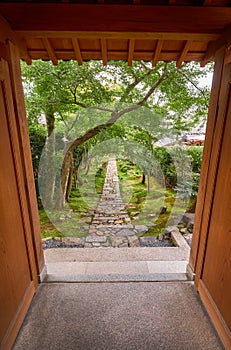 The view through the wooden gate to the garden with the stone road. Kyoto.Japan