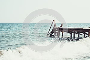 View of a wooden pier and seascape with running waves