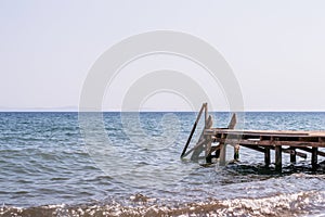 View of a wooden pier and seascape with running waves