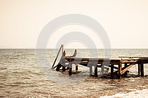 View of a wooden pier and seascape with running waves