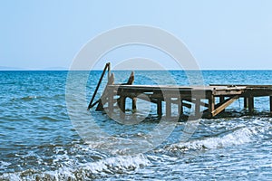 View of a wooden pier and seascape with running waves