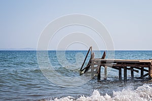 View of a wooden pier and seascape with running waves