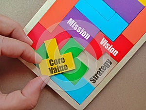 View of Wooden puzzle with text Core Value, Mission, Strategy and Vision on background.