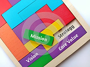 View of Wooden puzzle with text Core Value, Mission, Strategy and Vision on background.