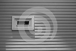 View of wooden window on gray wall of wooden house at countryside.